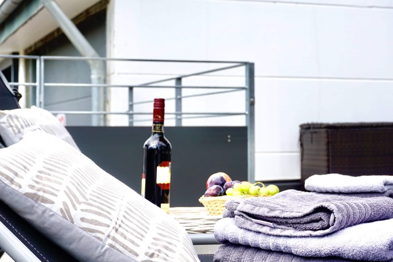 Liegestuhl mit Obst und Wein auf der Terrasse vom Ferienhaus Bodensee