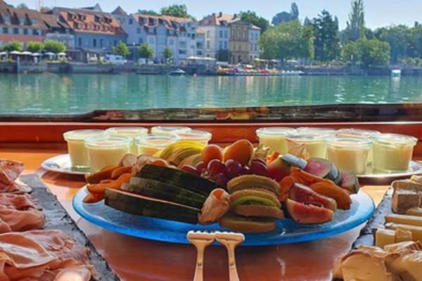 Brunchtbüffet mit Obst, Wurst und Käse auf dem Schiff der CMS Schifffahrt mit Blick auf die Uferpromenade am Bodensee