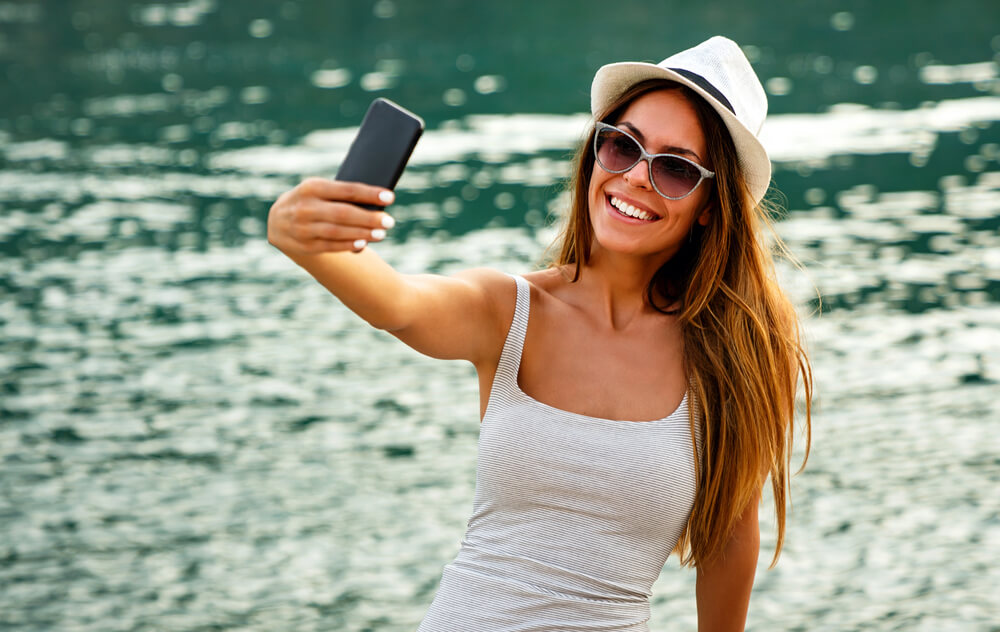 Roaming am Bodensee vermeiden – So schützen Sie Ihren Geldbeutel und Ihr Handy 2 Person mit Smartphone am Bodenseeufer – Grenzlage mit möglichem Netzwechsel zur Schweiz