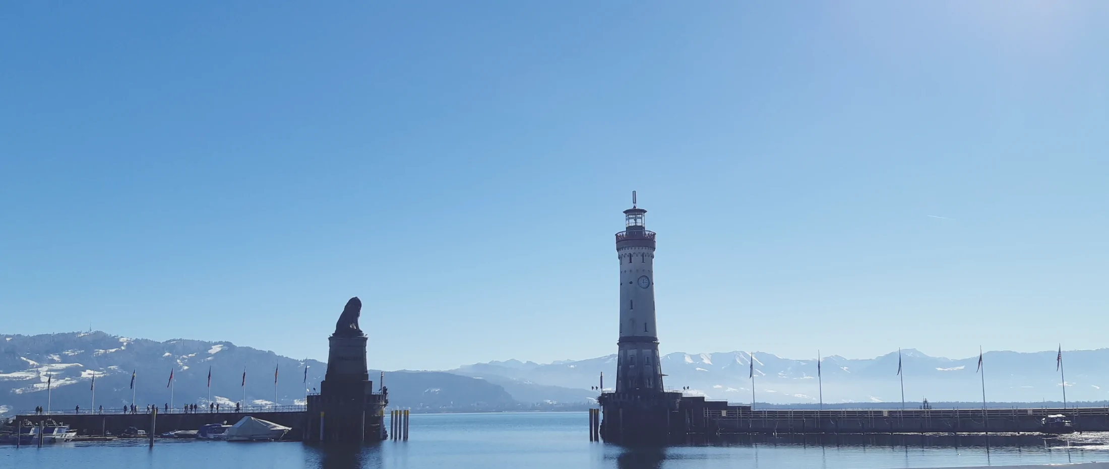Leuchtturm Lindau und Bayerischer Löwe an der Hafeneinfahrt mit Blick auf die Alpen